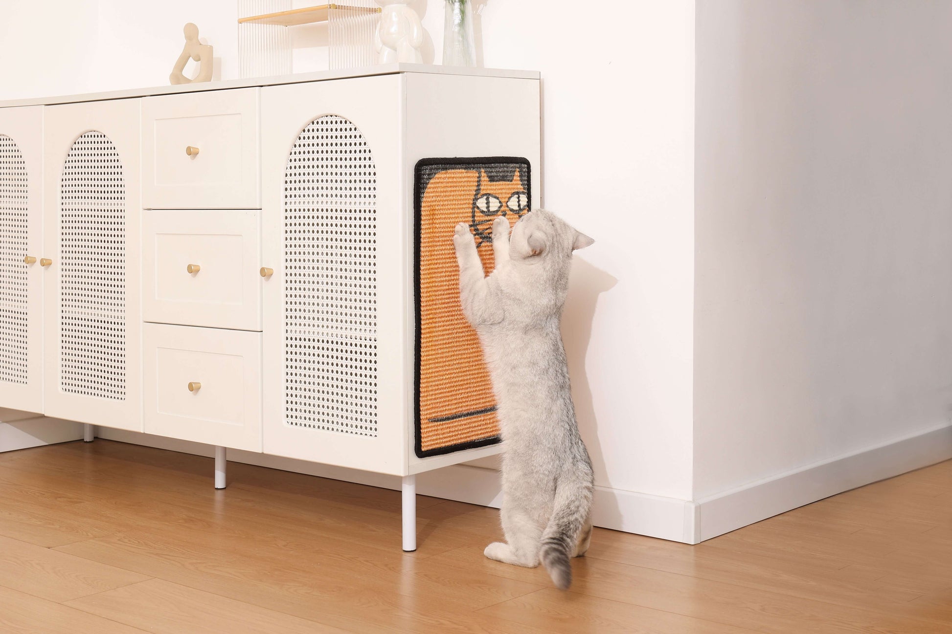 Cat scratching a natural sisal mat on a stylish cabinet, showcasing its art-inspired design and functionality.