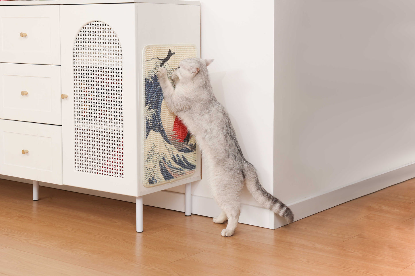 Cat scratching on an Art-Inspired Natural Sisal Scratching Mat beside a stylish cabinet.