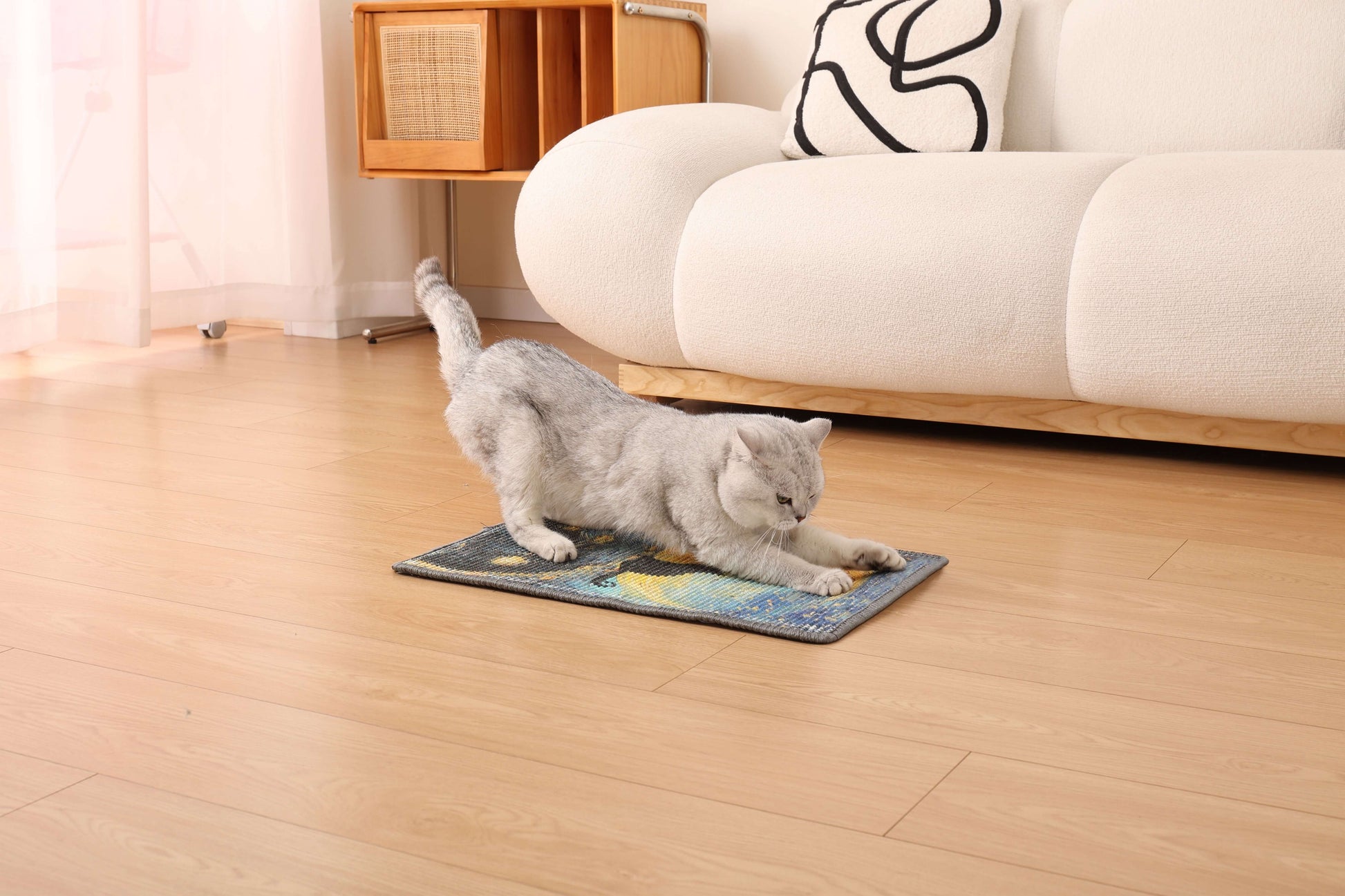Cat stretching on art-inspired sisal scratching mat in a stylish living room setting.