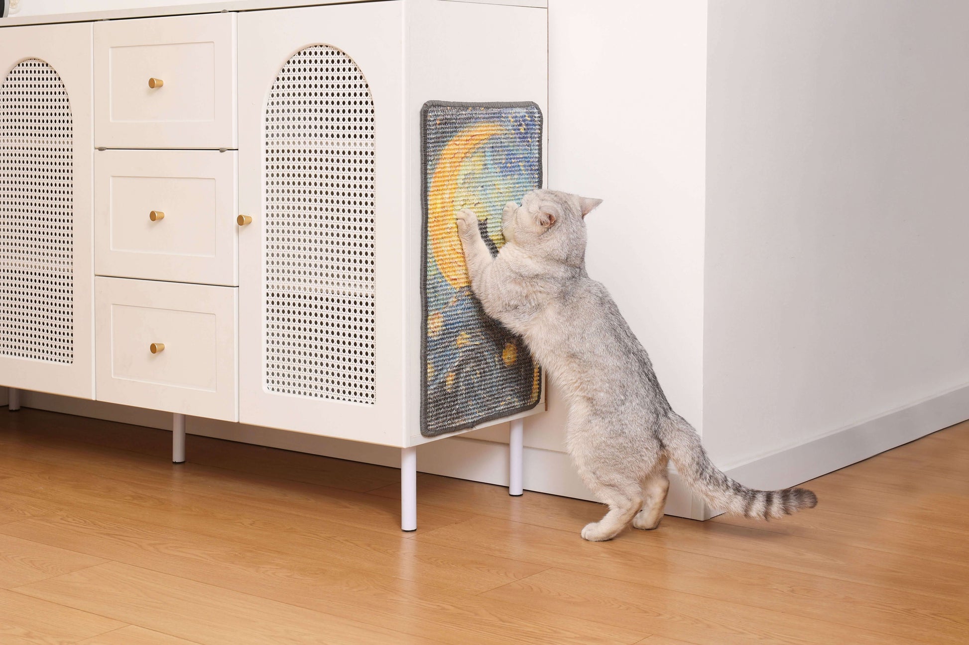 Cat enjoying an art-inspired natural sisal scratching mat on a stylish cabinet in a modern home.