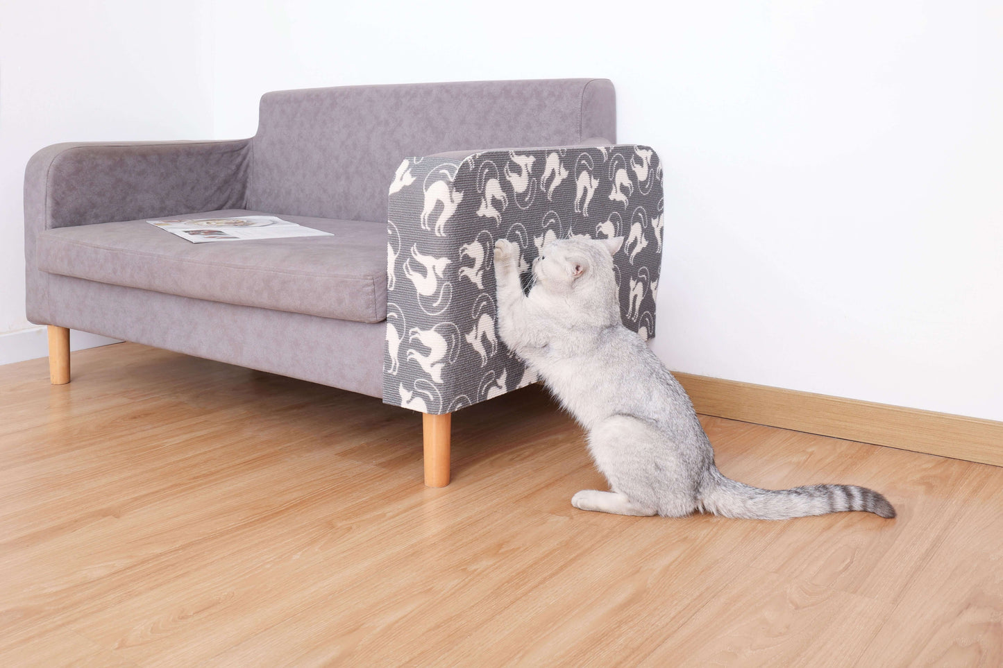 Cat using trimmable DIY scratching mat on sofa, blending with home decor.