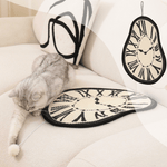 Melting clock cat scratching mat on a couch, featuring a playful cat and catnip pompom for entertainment.