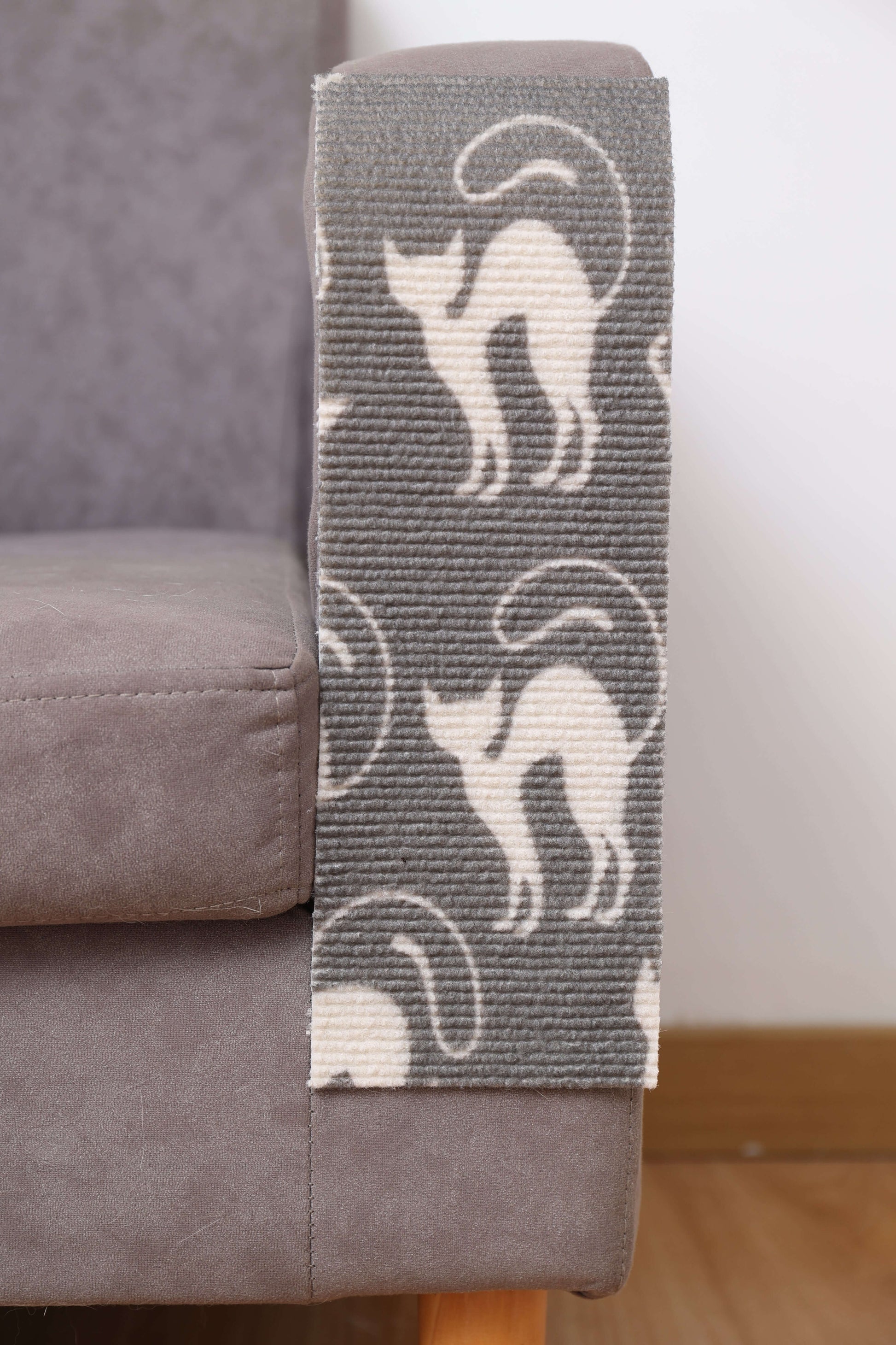 Trimmable DIY cat scratching mat with chic patterned design on couch, blends into home decor, secure self-adhesive backing.