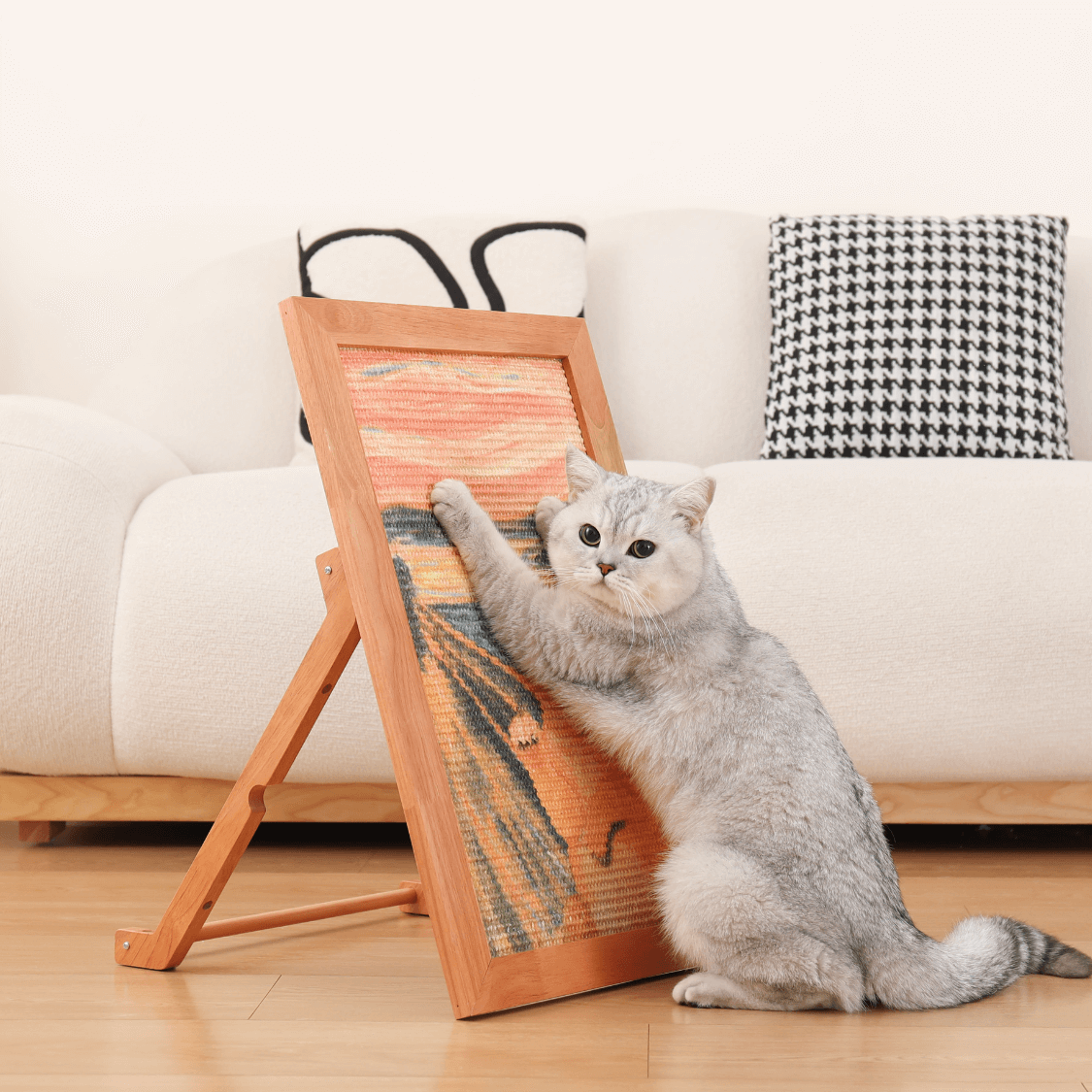 Gray cat using The Ultimate Art Scratcher, a stylish sisal cat scratcher and art display in a cozy living room.
