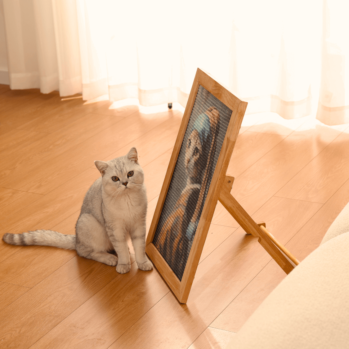 Gray cat next to a stylish sisal art frame scratcher, perfect for cat play and relaxation.