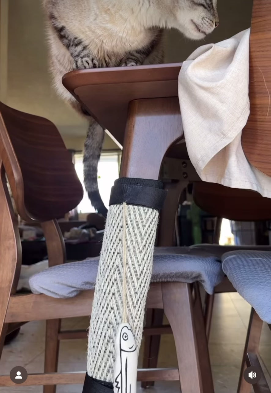 Multi-use table leg protector featuring sisal for cat scratching, with a hanging catnip fish toy.