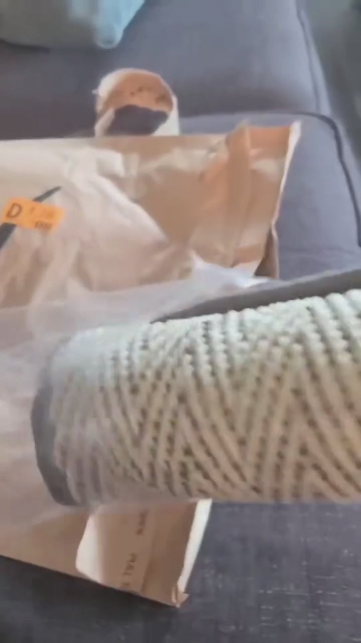 Close-up of a natural sisal scratching mat being unwrapped, highlighting its durable texture and packaging.